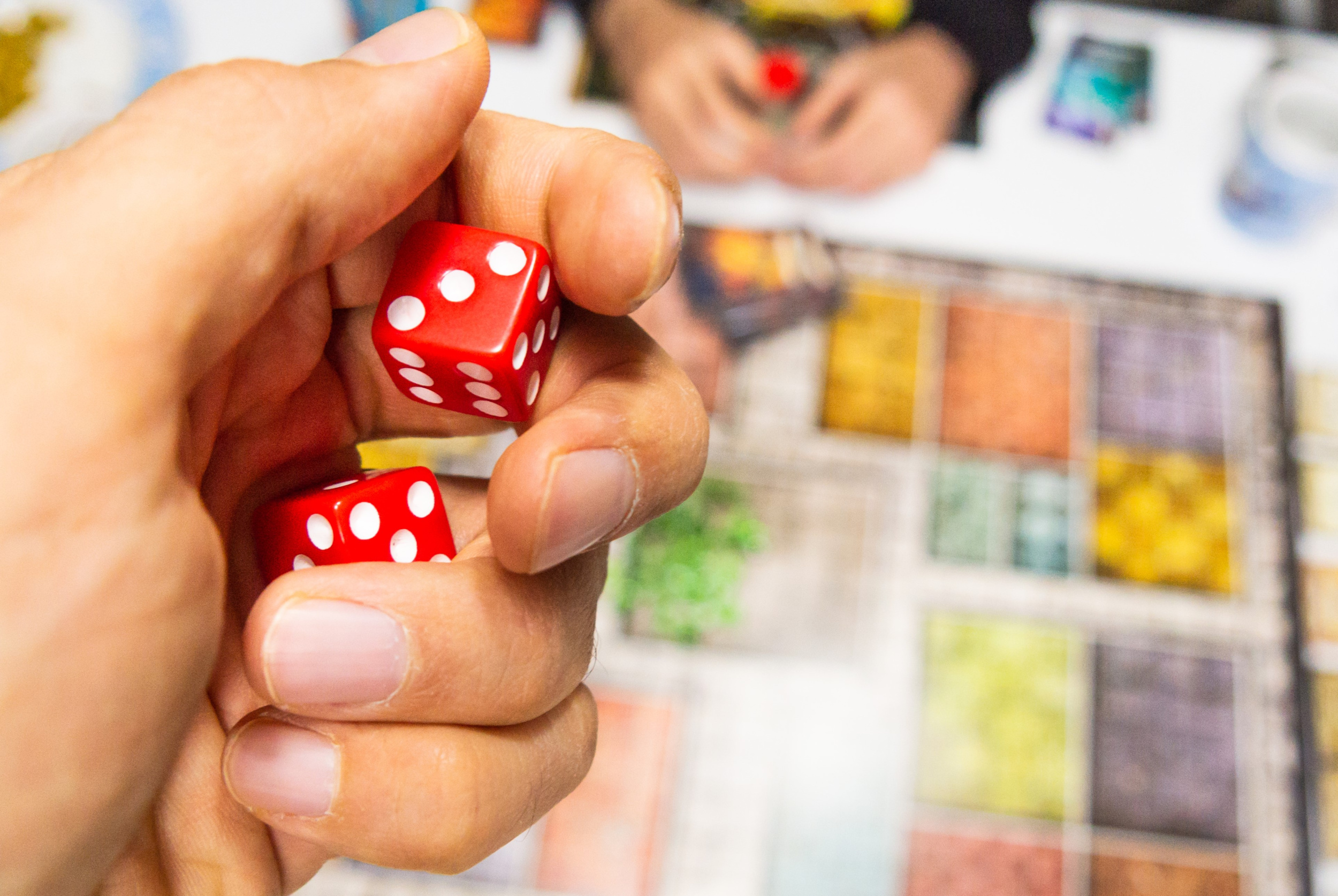 hand-with-red-dice-game-board-with-three.jpg hand-with-red-dice-game-board-with-three.jpg