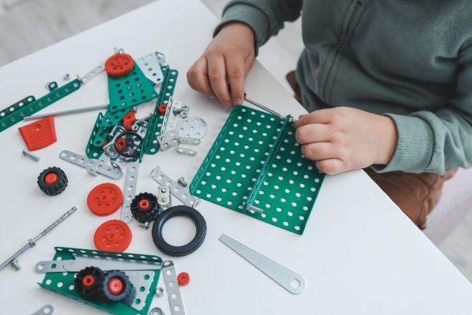 Мальчик собирает металлический конструктор.jpeg