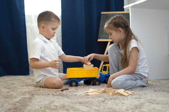 Брат и сестра играют с большой машиной.jpeg