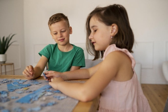 Брат и сестра собирают большой пазл.jpeg