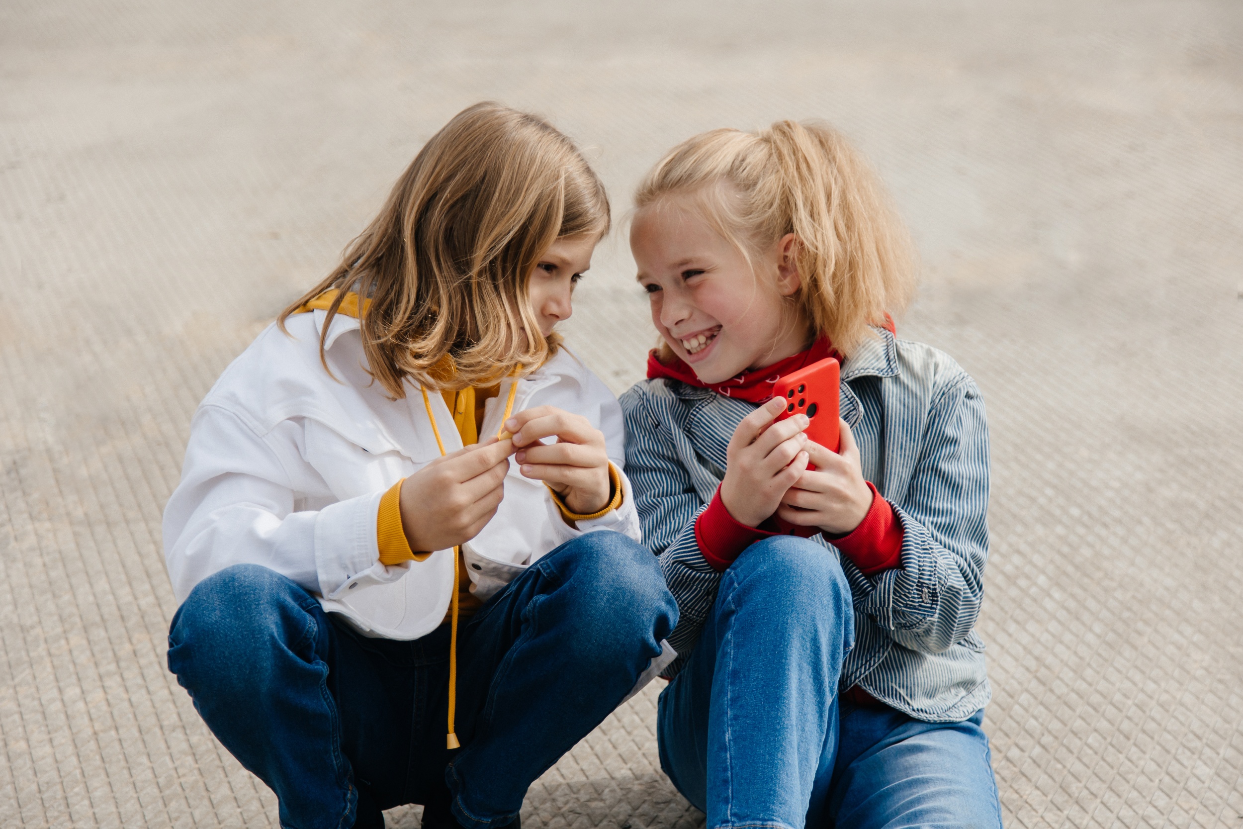 2 preteen-friends-boy-girl-play-smartphone-gadget-together.jpg