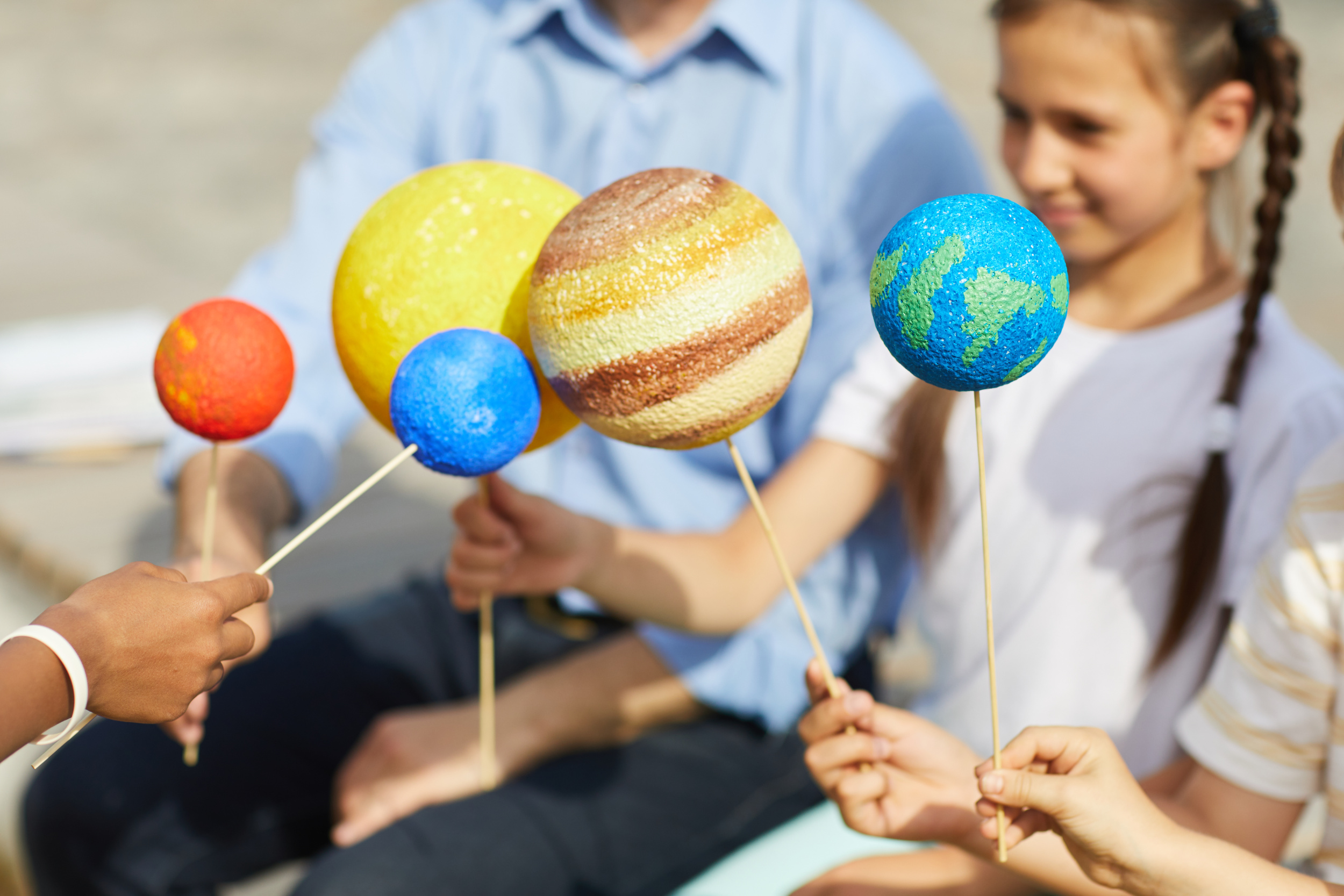 03 close-up-group-children-holding-model-planets-while-enjoying-outdoor-astronomy-lesson-sunlight-copy-space.jpg